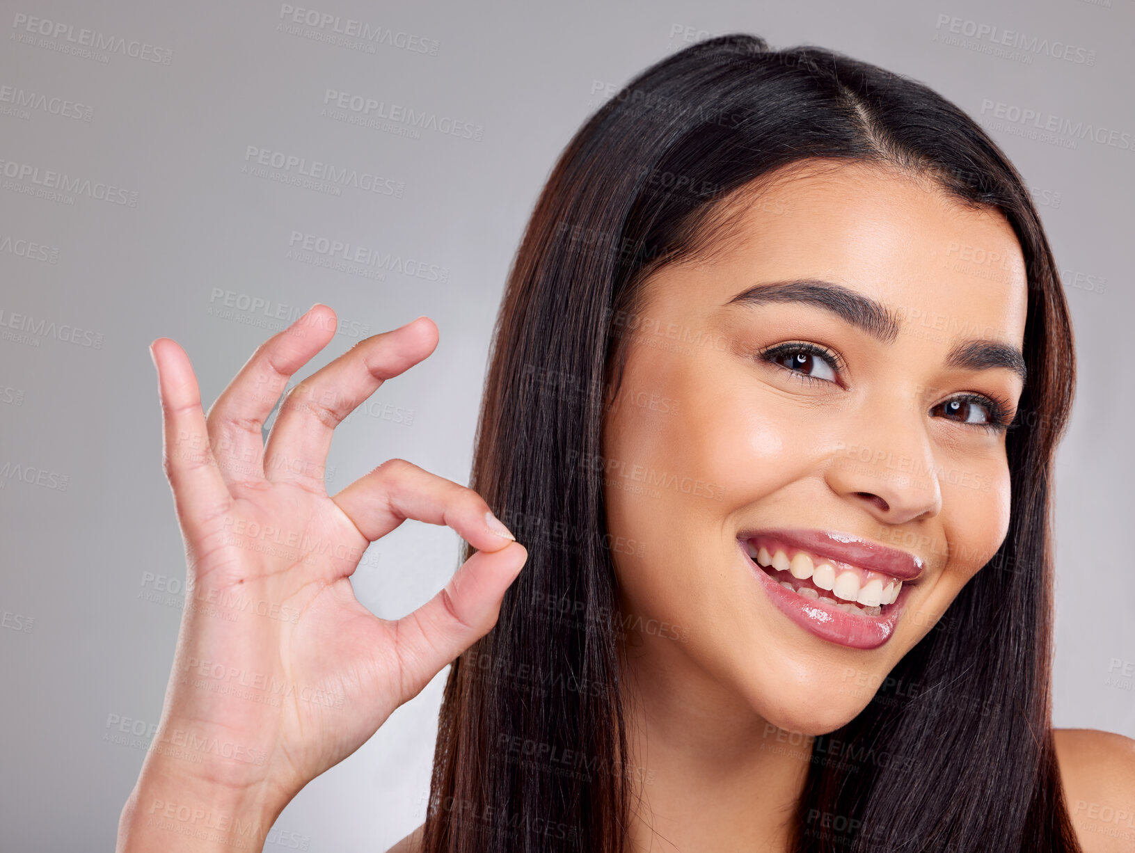 Buy stock photo Studio portrait of an attractive young woman posing against a grey background