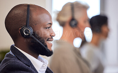 Buy stock photo Shot of a young call centre agent working in an office with his colleagues in the background