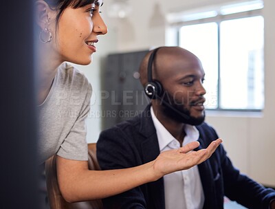 Buy stock photo Shot of two call centre agents working together in an office