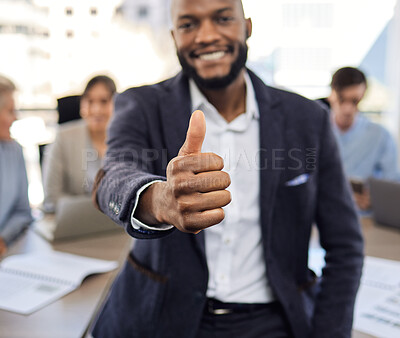 Buy stock photo Closeup shot of a young businessman showing thumbs up in an office with his colleagues in the background