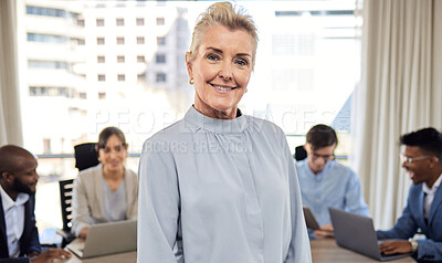Buy stock photo Portrait of a senior businesswoman standing in an office with her colleagues in the background