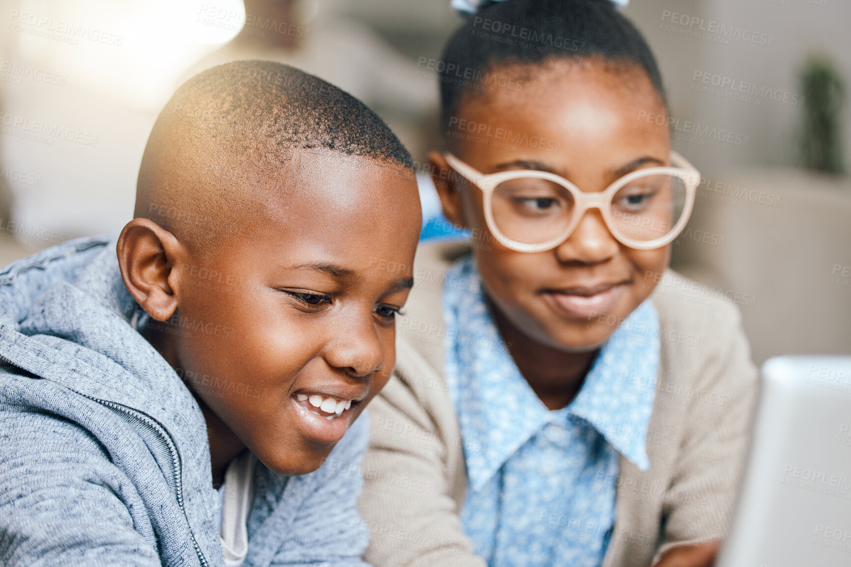 Buy stock photo Shot of a little brother and sister using a digital tablet together at home