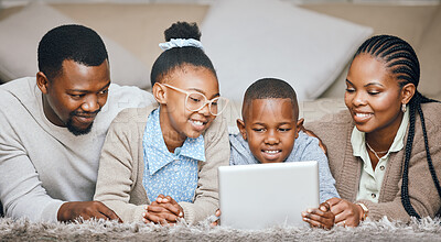 Buy stock photo Shot of a young family using a digital tablet at home