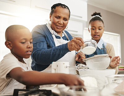 Buy stock photo Shot of a grandmother baking with her two grandkids at home