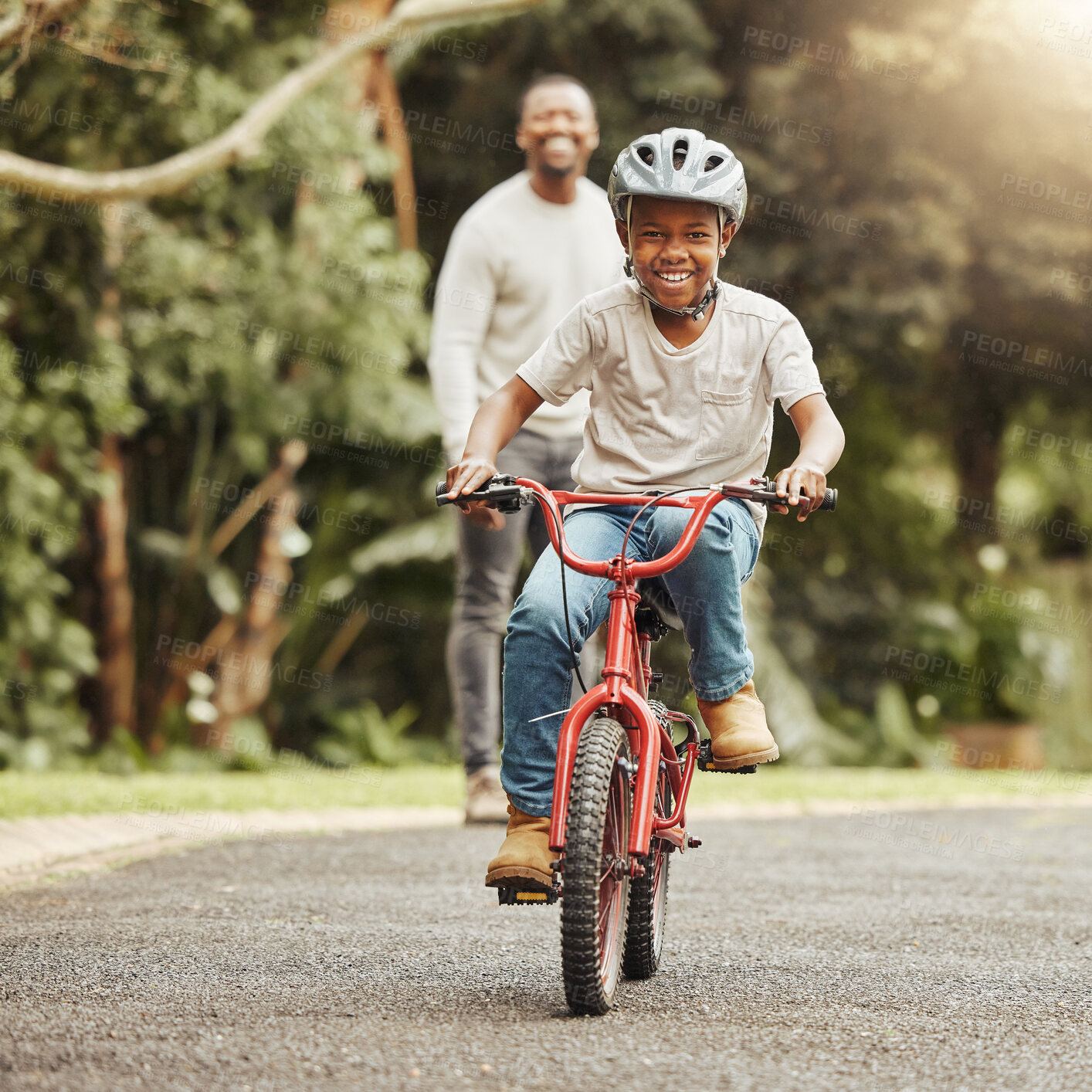 Buy stock photo Boy with smile on bicycle, father and learn cycling with help, helmet for safety and family in park. Support, motivation and trust, black man and young kid outdoor, teaching and learning bike riding