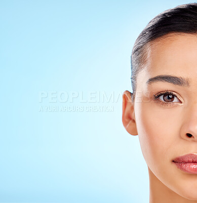 Buy stock photo Studio portrait of an attractive young woman posing against a blue background