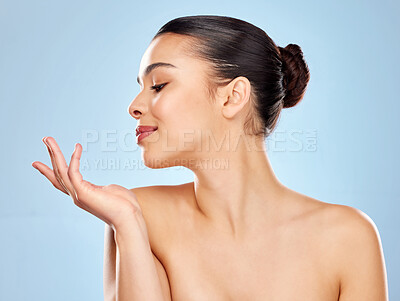 Buy stock photo Studio shot of an attractive young woman posing against a blue background