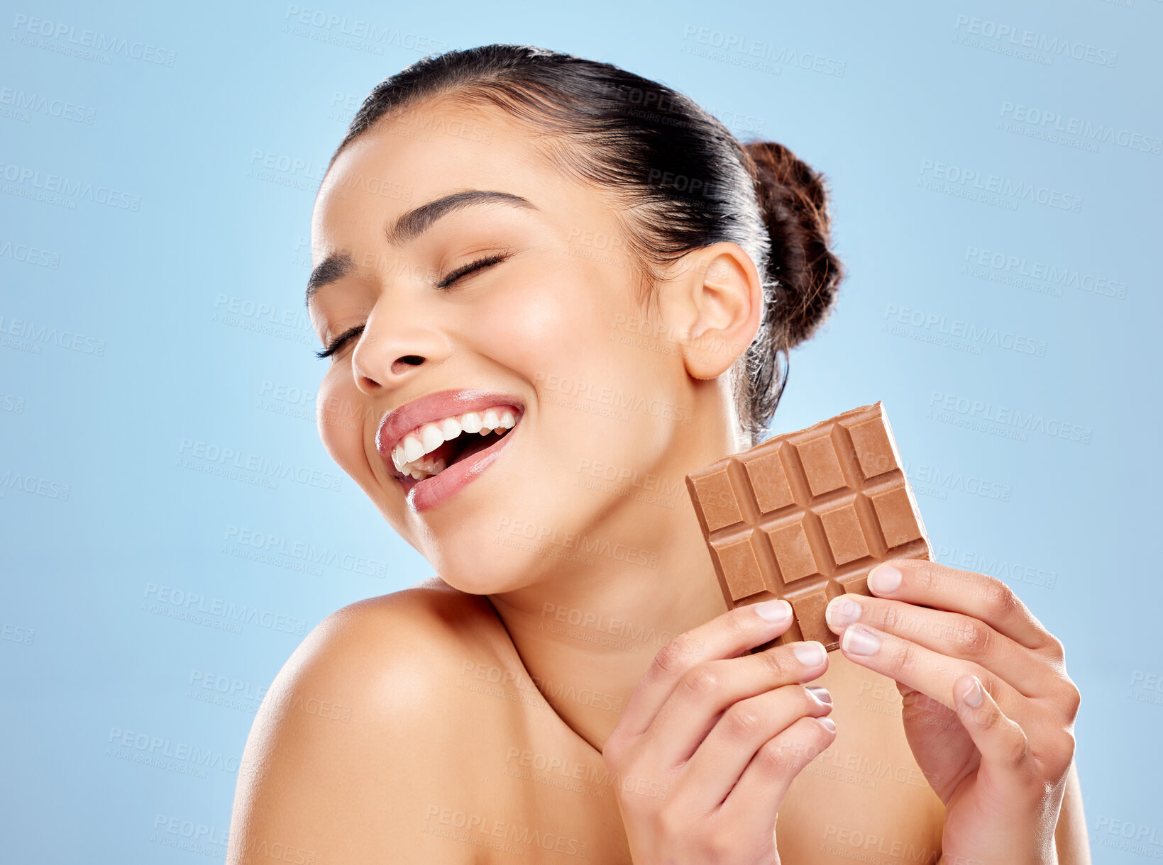 Buy stock photo Chocolate, woman and happy with benefits for skincare wellness and nutrition in studio. Model girl, food and health or results for diet, glow and excited face for antioxidants by blue background 