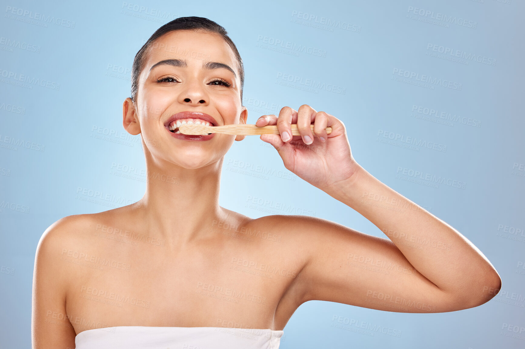 Buy stock photo Woman, portrait and brushing teeth in studio for cleaning, dental care and mouth wellness for hygiene. Bamboo, toothbrush and eco friendly product on blue background, fresh breath and oral health