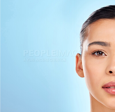 Buy stock photo Skincare, half face and woman in studio for beauty, glow and wellness or cosmetics for mockup. Model girl, laser and results for dermatology or chemical peel by blue background with shine from facial