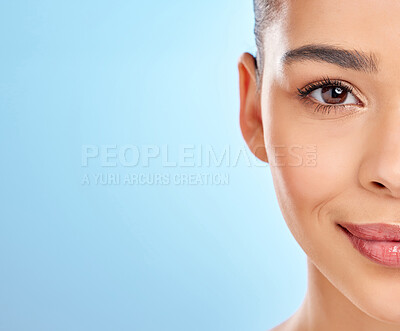 Buy stock photo Studio portrait of an attractive young woman posing against a blue background