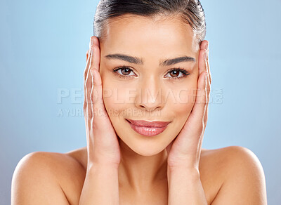 Buy stock photo Skincare, woman and touching face in studio for beauty, glow and wellness or cosmetics. Model girl, hands and smile for results, dermatology and chemical peel by blue background and shine from facial