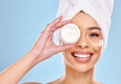 Buy stock photo Studio portrait of an attractive young woman holding a beauty product against a blue background