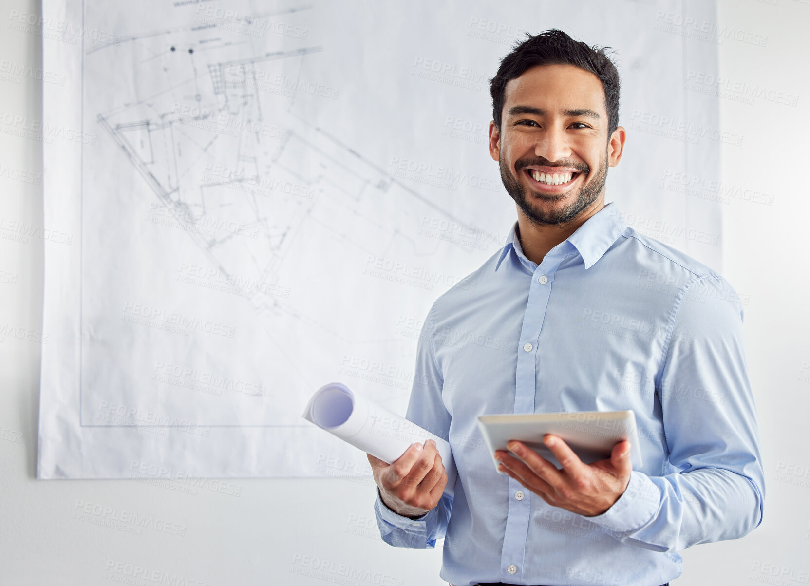 Buy stock photo Shot of a young male architect using a digital tablet at work