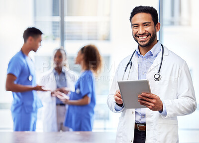 Buy stock photo Shot of a young male doctor using a digital tablet at work