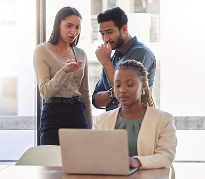 Buy stock photo Office bully, woman and working at laptop with coworkers talking in a corporate workplace with gossip. Young black person typing on a computer with internet and joke with staff being mean at desk