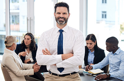 Buy stock photo Shot of a young businessman standing with her arms crossed in a meeting at work