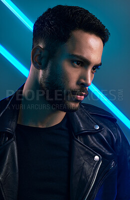 Buy stock photo Conceptual shot of a stylish young man posing in studio against a blue background