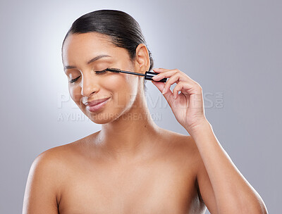 Buy stock photo Brush, mascara and woman in studio for makeup, cosmetics and results on grey background. Eyelash, curling and face of Indian female model with beauty tool for treatment, application or volume