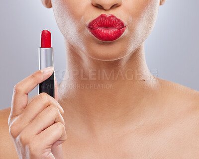 Buy stock photo Cropped shot of an unrecognisable woman holding red lipstick and pouting in the studio