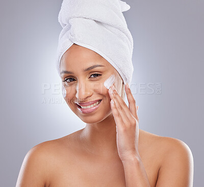 Buy stock photo Studio, woman and towel for cream or cosmetics, moisturizer and hand on white background. Skincare, dermatology and beauty for female person, smile or portrait for lotion with glow or product on face