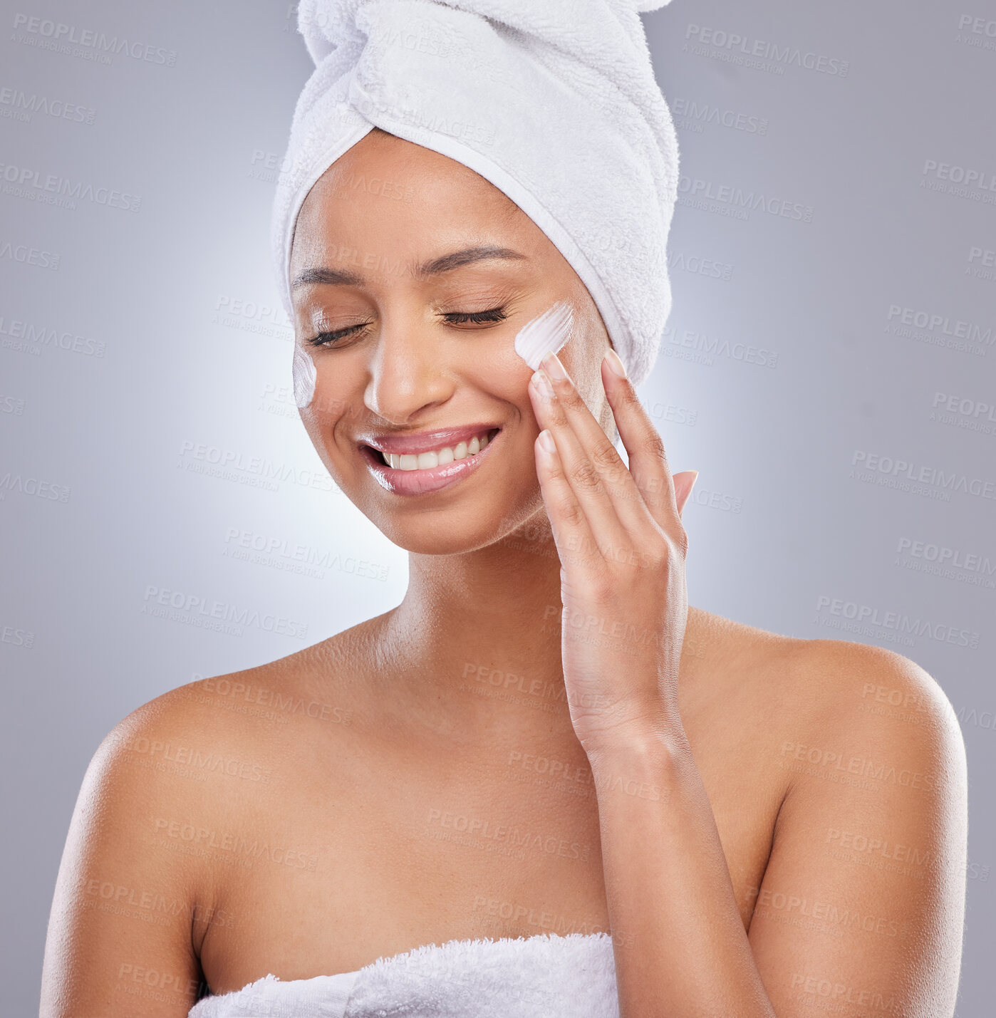 Buy stock photo Hand, woman and towel for cream or cosmetics, moisturizer and studio on white background. Skincare, dermatology and beauty for female person, smile or relax for lotion with glow and product on face