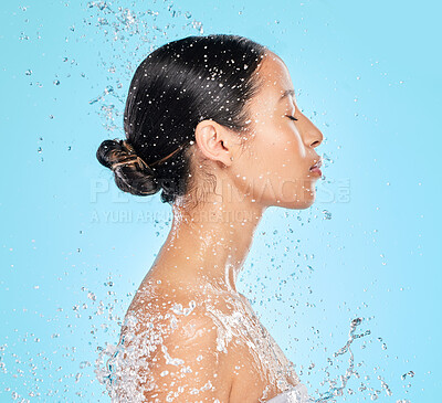 Buy stock photo Skincare, water and profile of woman on blue background for wellness, healthy skin and cleaning in studio. Beauty, shower and female person with splash for facial grooming, washing and body care