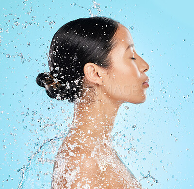Buy stock photo Beauty, water and face profile of woman on blue background for wellness, healthy skin and cleaning. Bathroom, shower and female person with splash for facial grooming, washing and skincare in studio