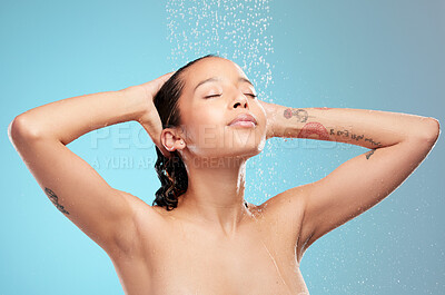 Buy stock photo Shot of a beautiful young woman enjoying a shower against a blue background