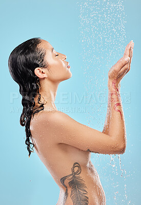 Buy stock photo Shot of a beautiful young woman enjoying a shower against a blue background