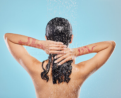 Buy stock photo Shot of a beautiful young woman enjoying a shower against a blue background