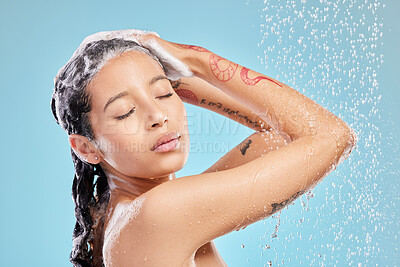 Buy stock photo Shot of a beautiful young woman enjoying a shower against a blue background