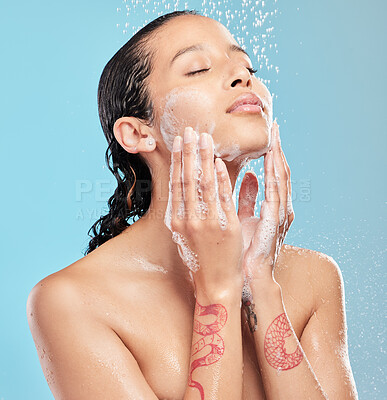 Buy stock photo Shot of a beautiful young woman enjoying a shower against a blue background