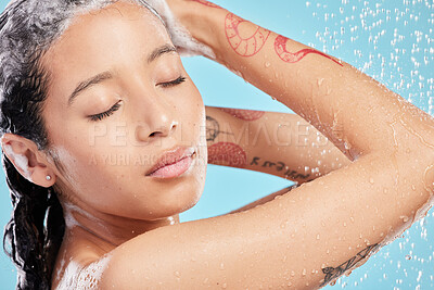 Buy stock photo Shot of a beautiful young woman enjoying a shower against a blue background