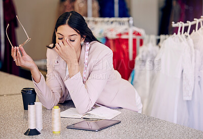 Buy stock photo Headache, tired and a fashion designer at a boutique for planning, burnout and sad from design fail. Stress, workshop and a woman with anxiety, fatigue or depression from working as a tailor