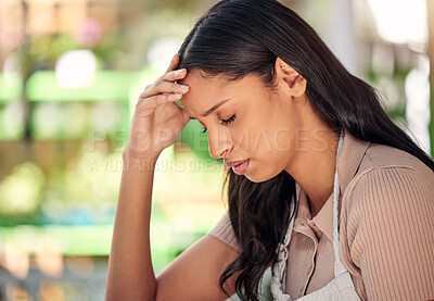 Buy stock photo Shot of a young florist suffering from a headache at work