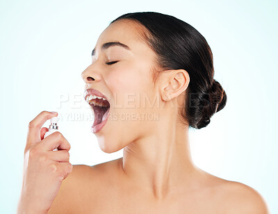 Buy stock photo Cropped shot of an attractive young woman using breath freshener against a light background