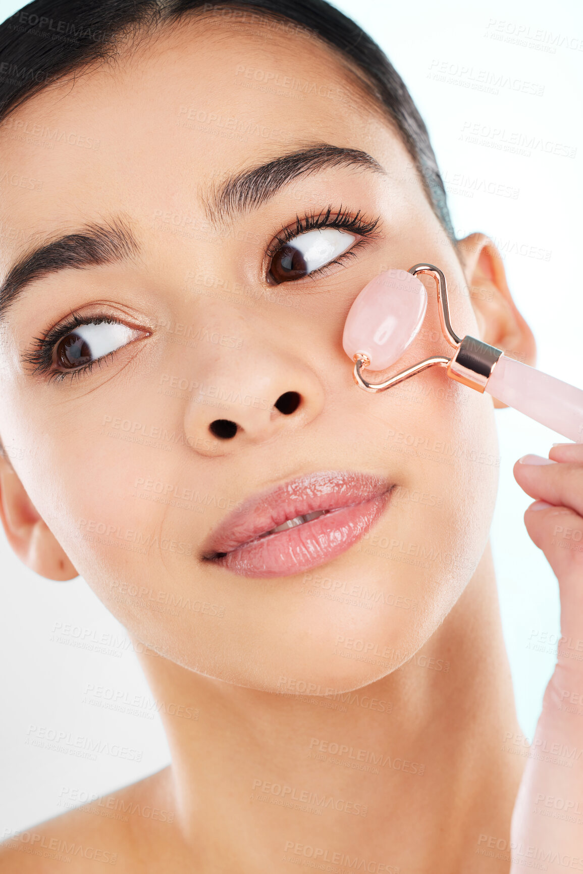 Buy stock photo Face roller, massage and skincare of woman with health, beauty or wellness isolated on studio background. Glow, cosmetics or model with rose quartz stone for dermatology, facial or lymphatic drainage