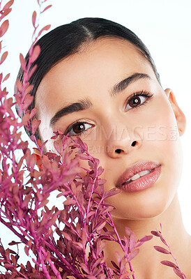 Buy stock photo Studio portrait of an attractive young woman posing with a pink bush against a light background