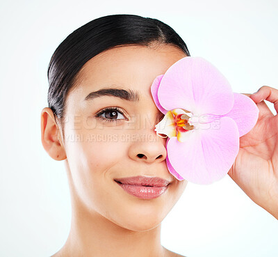 Buy stock photo Studio portrait of an attractive young woman posing with a pink orchid against a light background