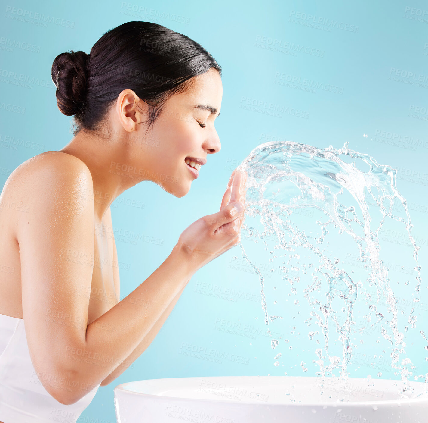 Buy stock photo Studio, basin and woman with water splash in face for natural cleaning, hygiene and morning routine. Profile, hand and female person with liquid for skincare, health or dermatology on blue background