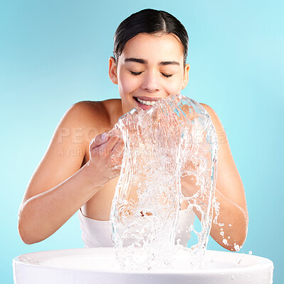 Buy stock photo Shot of a young woman doing her daily skincare routine against a blue background