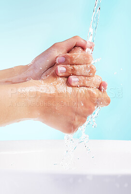 Buy stock photo Shot of an unrecognizable woman washing her hands against a blue background