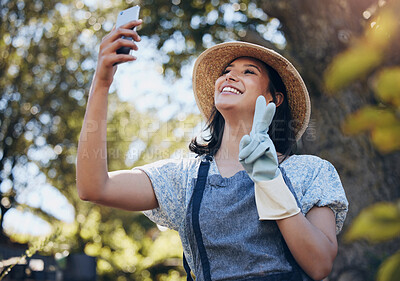 Buy stock photo Happy, woman and florist taking selfie with smartphone for social media, networking outdoor in nature at nursery. Excited, female person and peace sign with mobile for connection and entertainment