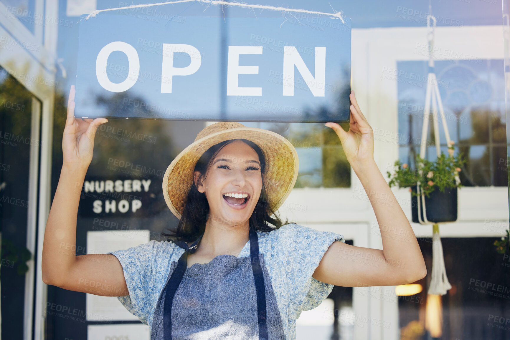 Buy stock photo Portrait, nursery and open with a woman hanging a sign in the window of her shop for gardening. Small business, garden center and an excited young female entrepreneur opening her new flower store