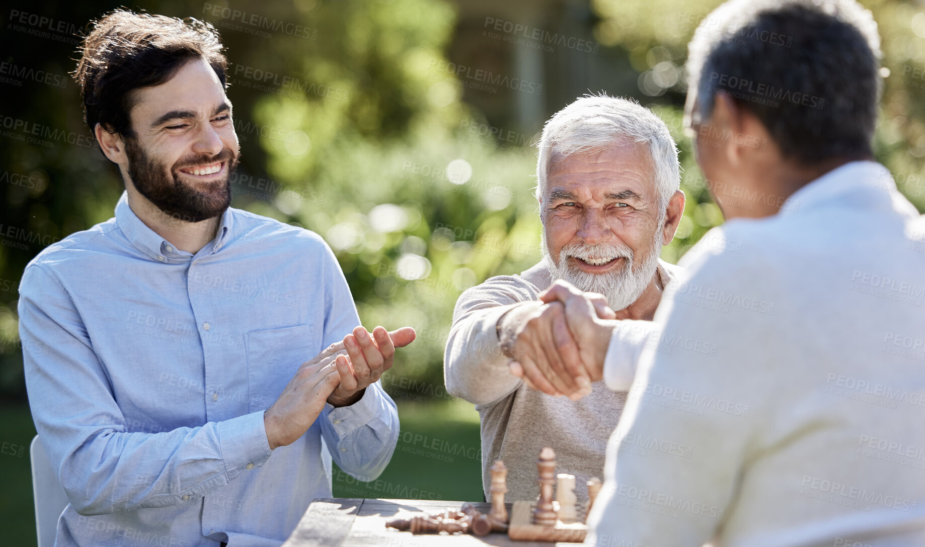 Buy stock photo Group, men and handshake in garden for chess, retirement and friends for strategy game in park. Shaking hands, applause for winner and social in countryside for senior man and boardgames in nature