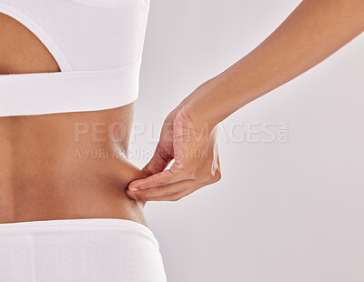 Buy stock photo Cropped shot of an unrecognizable woman pulling on the skin on her waist