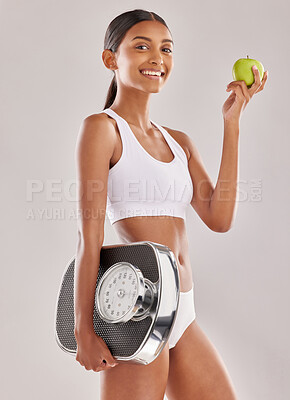 Buy stock photo Woman, body and apple with scale and lose weight, smile in portrait with health and nutrition on studio background. Happy female model, healthy food and fruit with diet, detox and vegan lifestyle