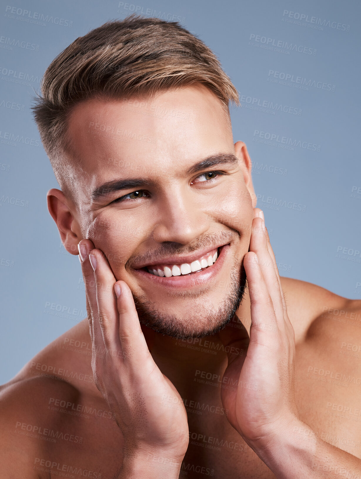 Buy stock photo Closeup shot of a handsome young man smiling while posing against a studio background