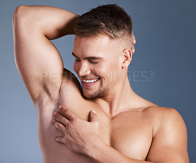 Buy stock photo Shot of a man looking satisfied while touching his underarms